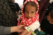 A girl has her arm measured with the child arm circumference by the MUAC tape.