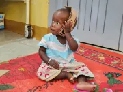 A child playing with her new cardboard toy.