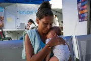 A woman holds a baby in her arms.