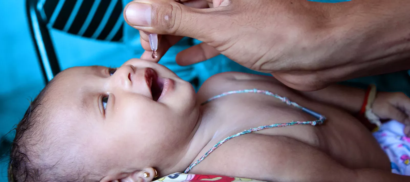 A baby is administered an oral vaccine. 