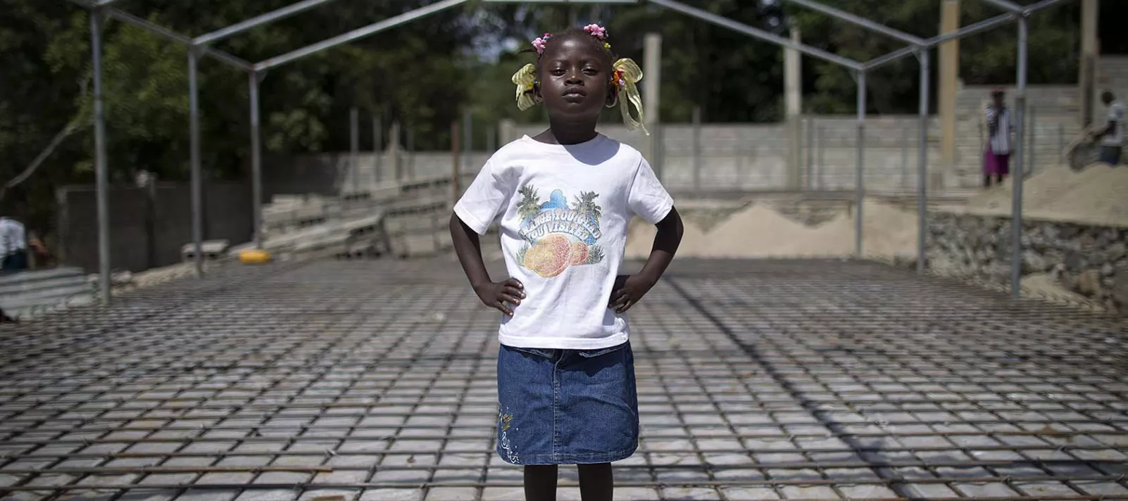 Seven-year-old Edeline Jean stands on the foundation of the building of a new school in Haiti.