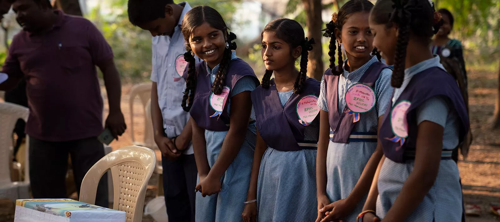 A group of teenage girls stand and wait to receive soap at a SWAVOS meeting at Zilla Parishad High School Veldhi, India, February 2019.