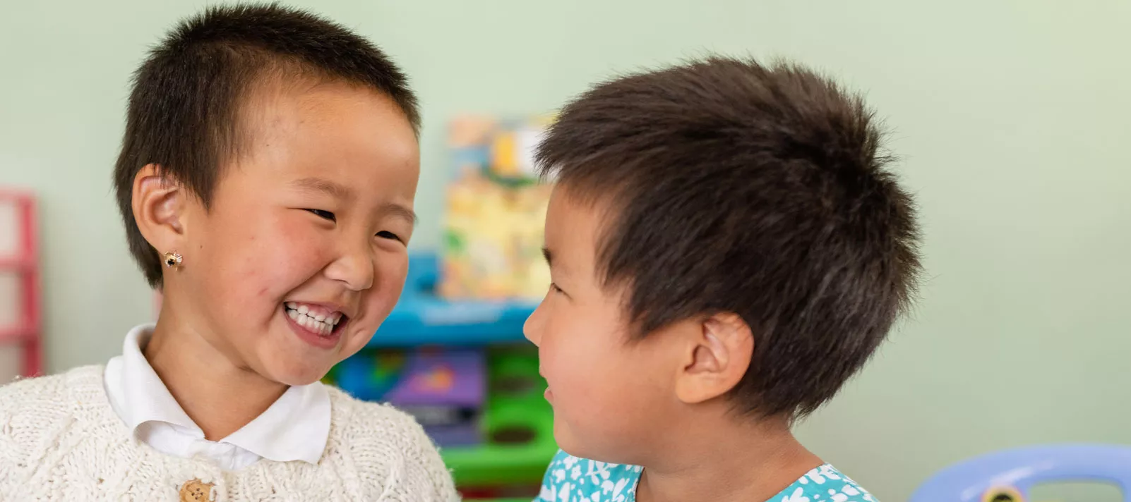 Two small girls smile to each other at an early childhood development center, supported by UNICEF, in Ulaanbaatar, Mongolia, in September 2018.