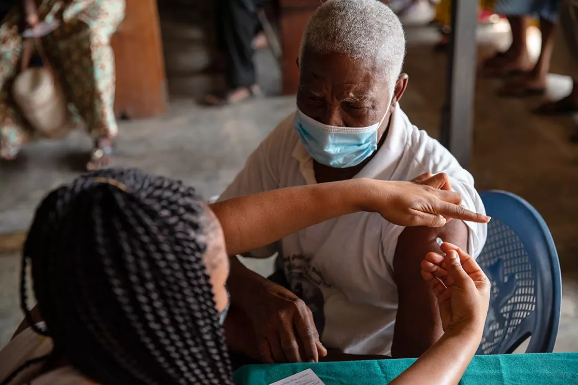 A healthcare staff administers a jab of the Oxford/AstraZeneca vaccine at the Kasoa Polyclinic, in Kasoa, Ghana, in March 2021.