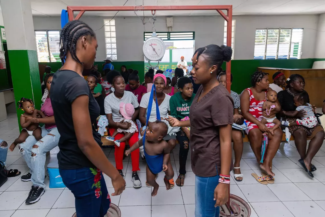 A baby is weighed on a scale in the healthcare centre.