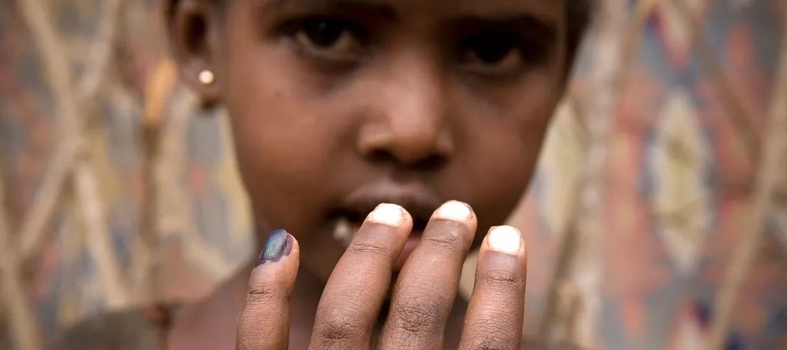 A child shows her finger, marked by a community health worker after having been vaccinated during a UNICEF-supported immunisation campaign in Ifo, in the north-eastern province of Kenya in August 2011.