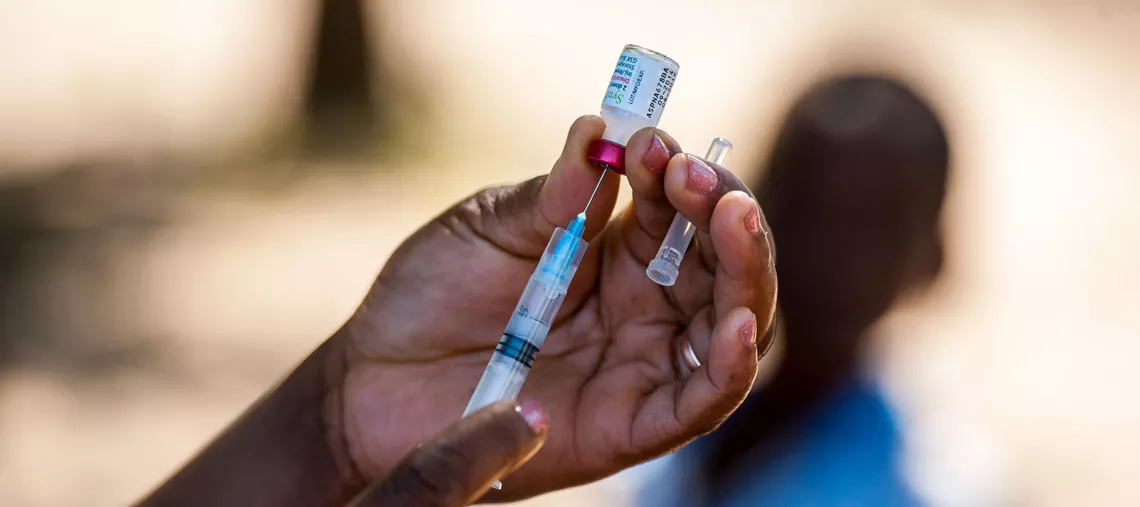 The hands of a medical practitioner filling a syringe before administering a pneumococcal vaccine in Mapai district, Gaza Province, Mozambique, in July 2016.
