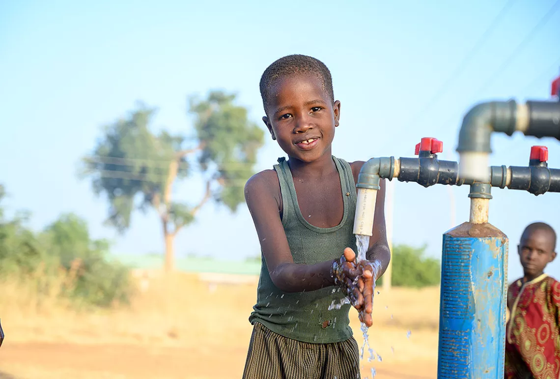 Eight-year-old Abdul Mohammed washes his hands and face at a borehole constructed by UNICEF at Dongonkuka Primary Healthcare Centre.