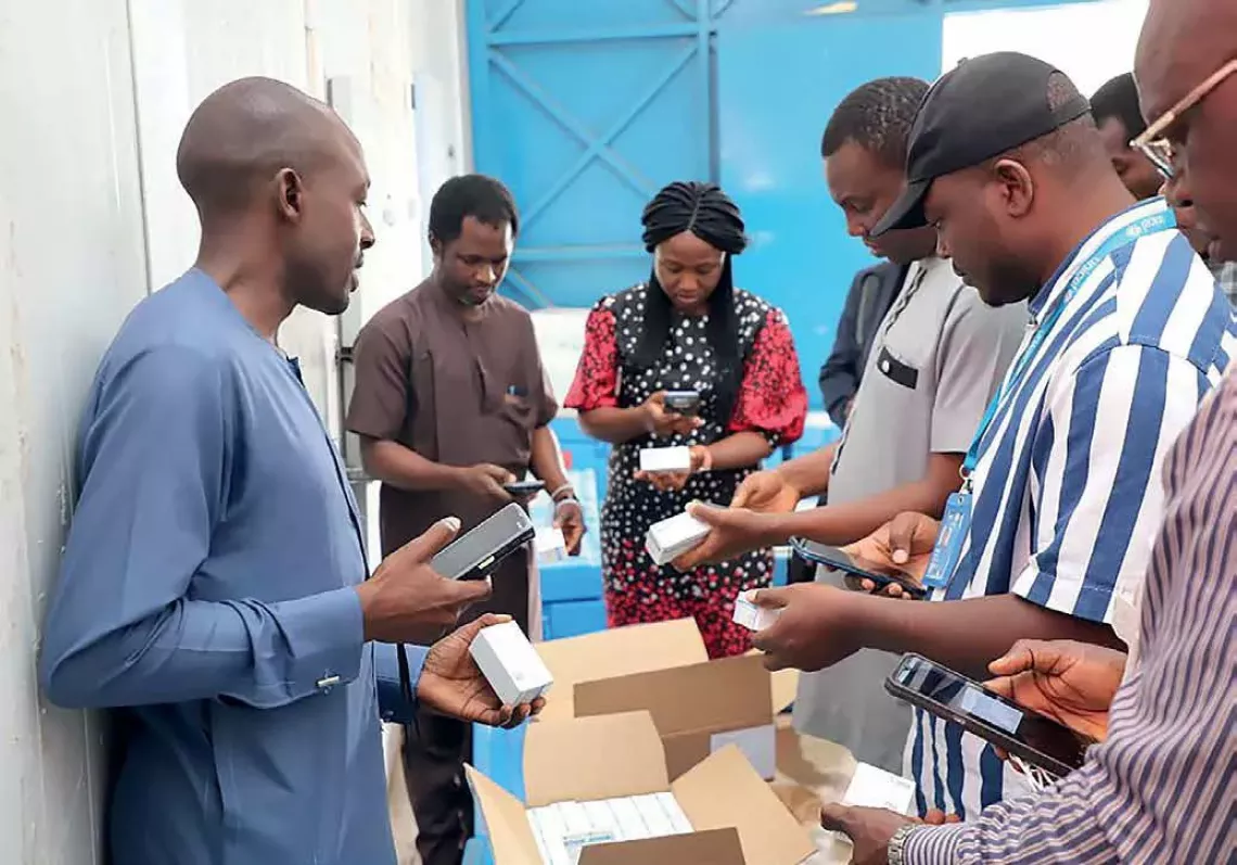 Five healthcare workers examine their mobile phones to control the barcodes of medical supplies. 
