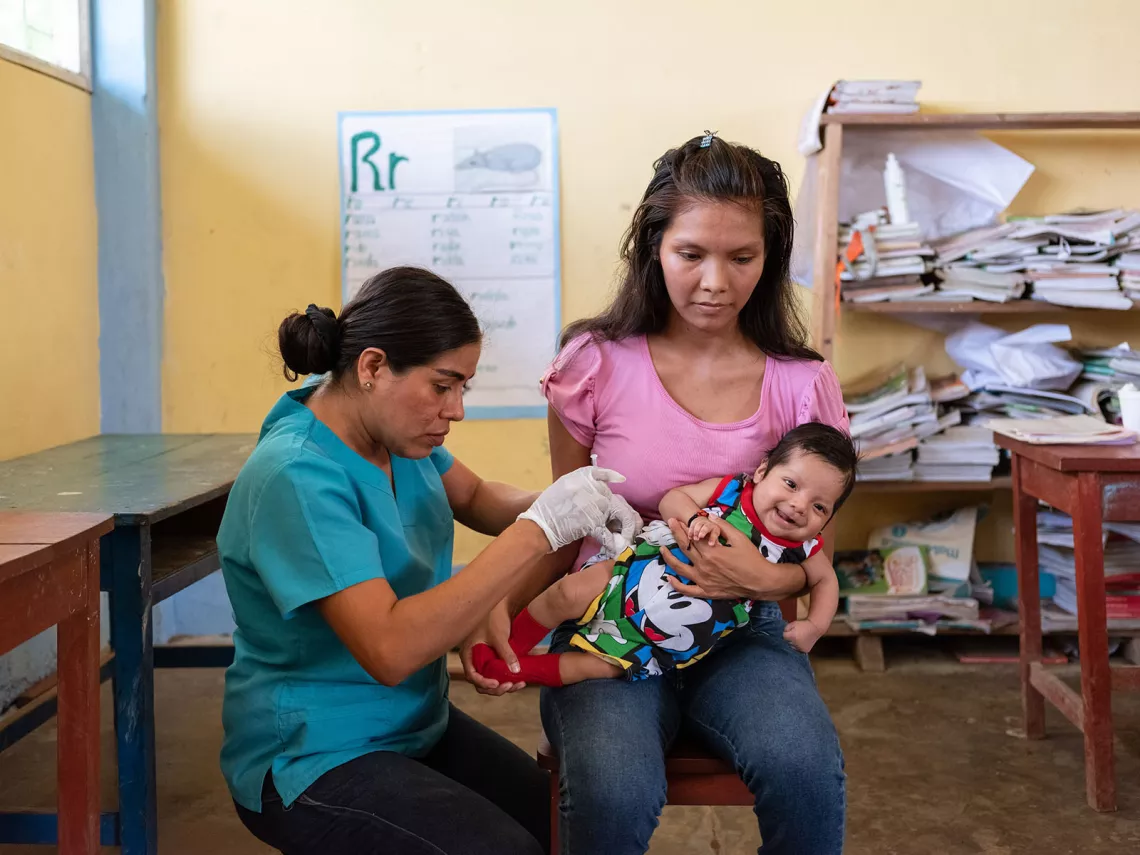 Health worker vaccinating a 2-month-old child