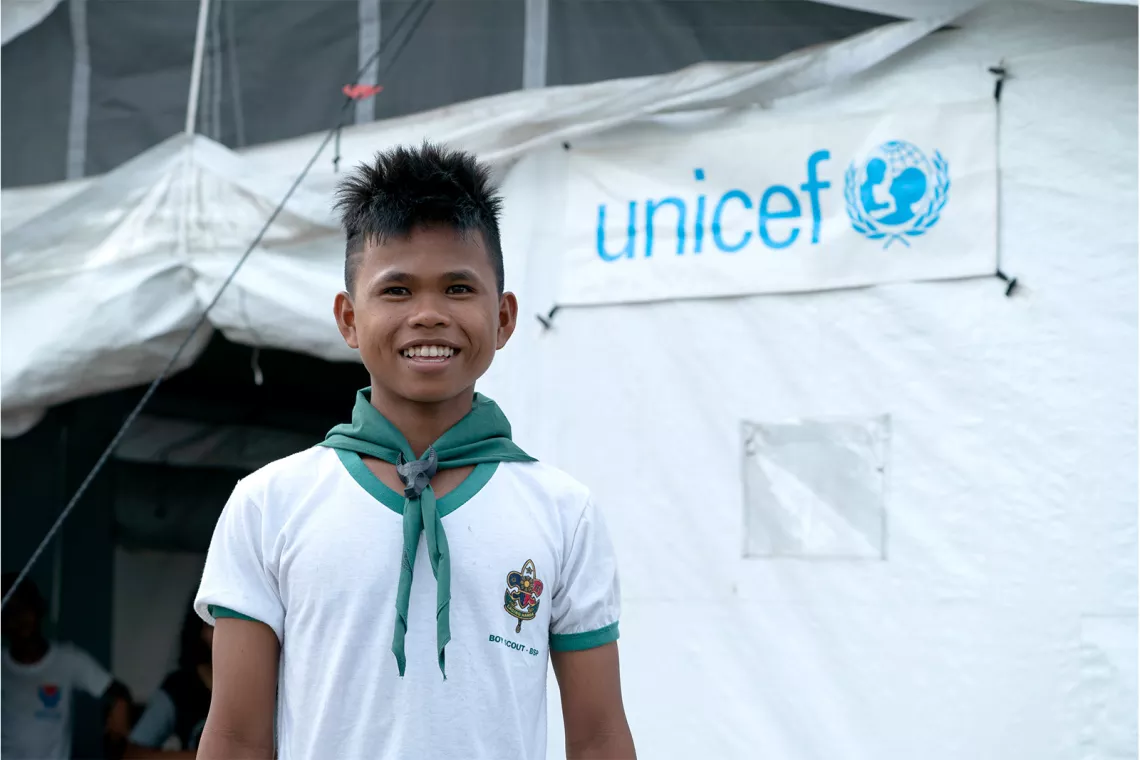 Boy standing in front of a UNICEF High Performance Tent