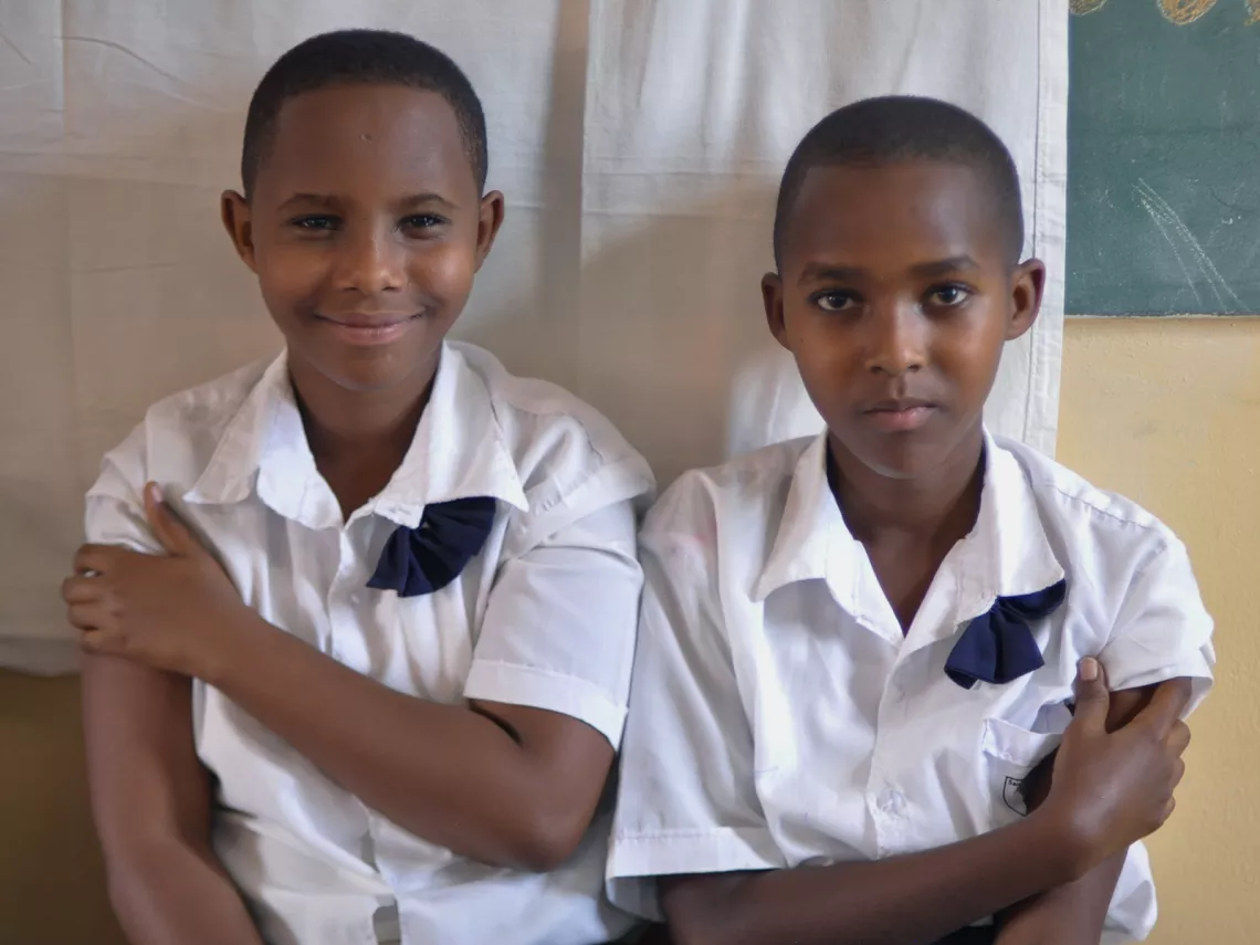 Two girls sit together after receiving their HPV vaccinations