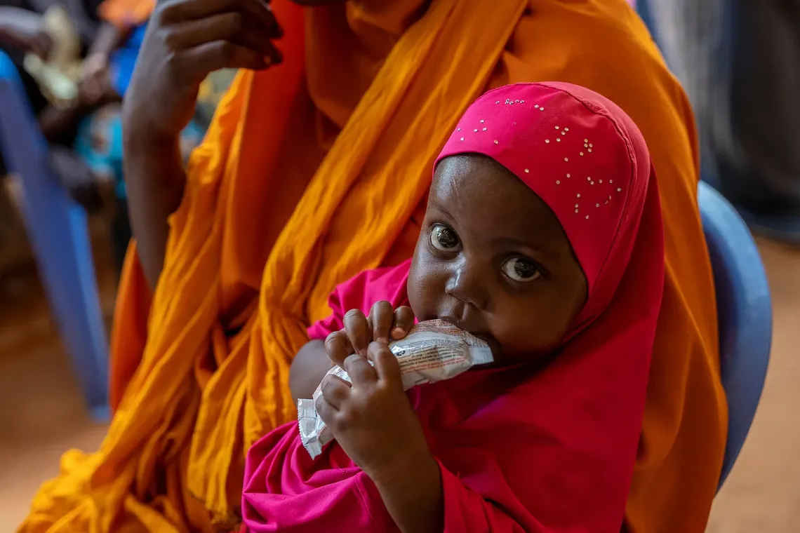 A baby child eats Ready-to-use therapeutic food (RUTF).