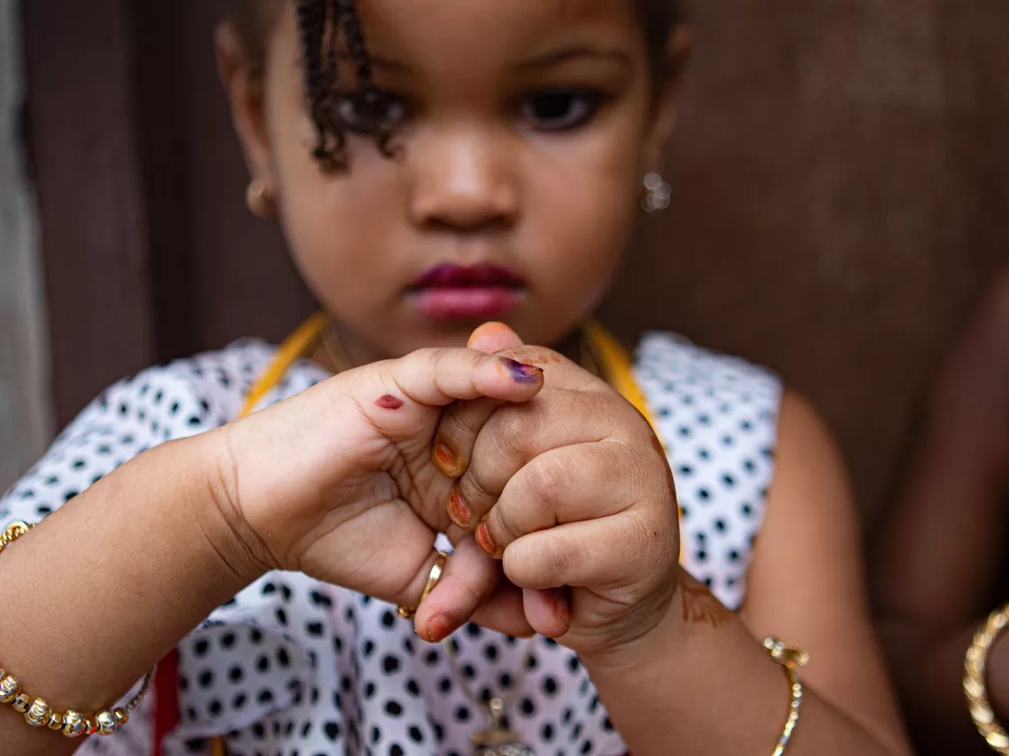 A young girl shows her marked finger indicating she has received the polio vaccine