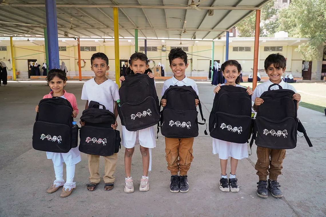 Students are proudly showing their black UNICEF backpacks at their school in Yemen. 