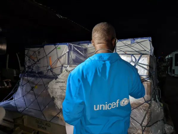 A UNICEF staff inspects a vaccine shipment.