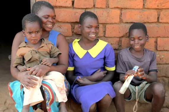 Benalita with Andrew, Lucy, and their brother in their village in Malawi.