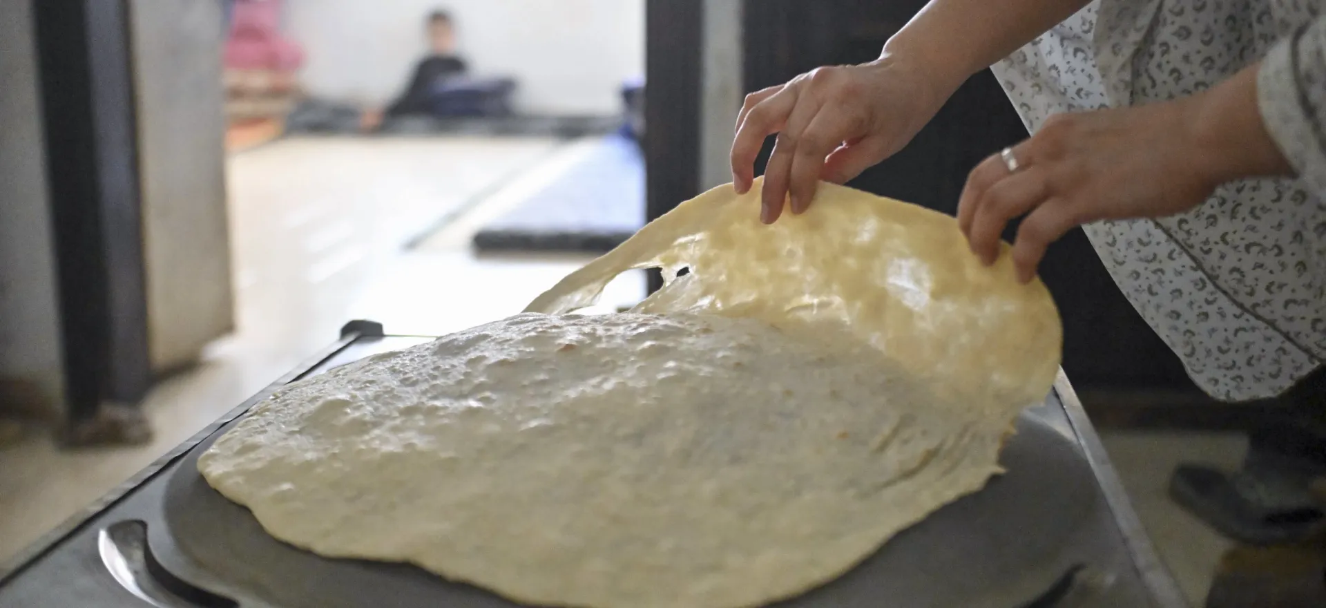 Manal prepares bread for her family in their apartment in Shabaa village, Rural Damascus.