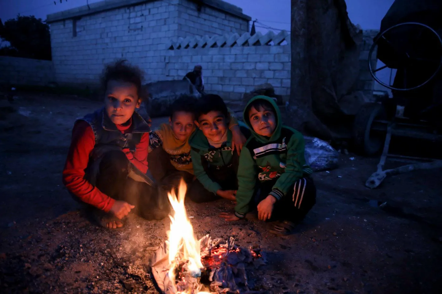 children gathered around fire in a camp