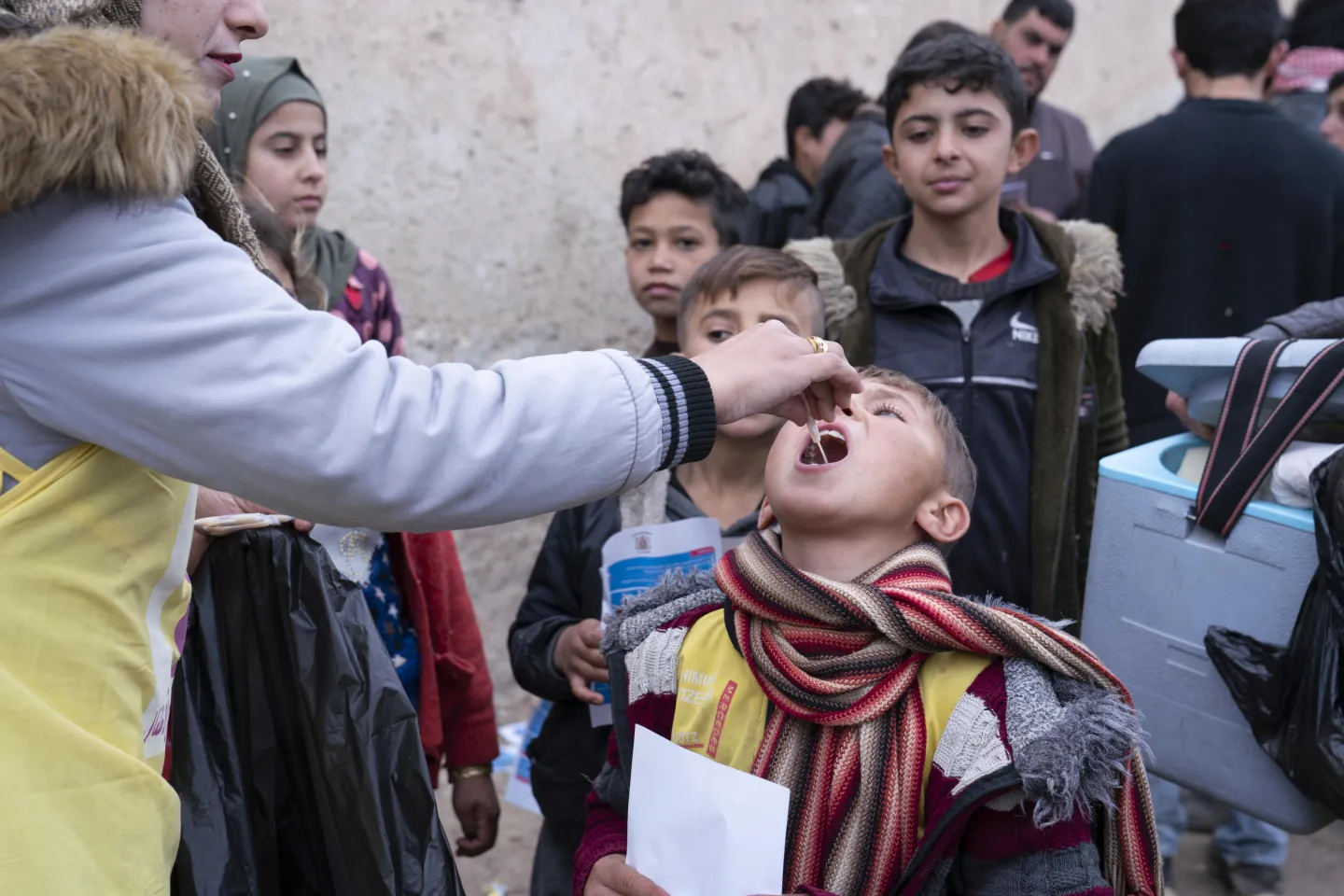young boy with head back and open mouth receives vaccine drops