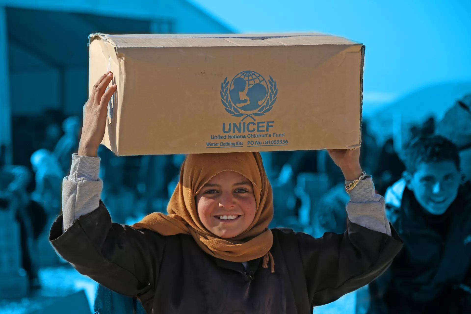 girl holding non food items UNICEF box