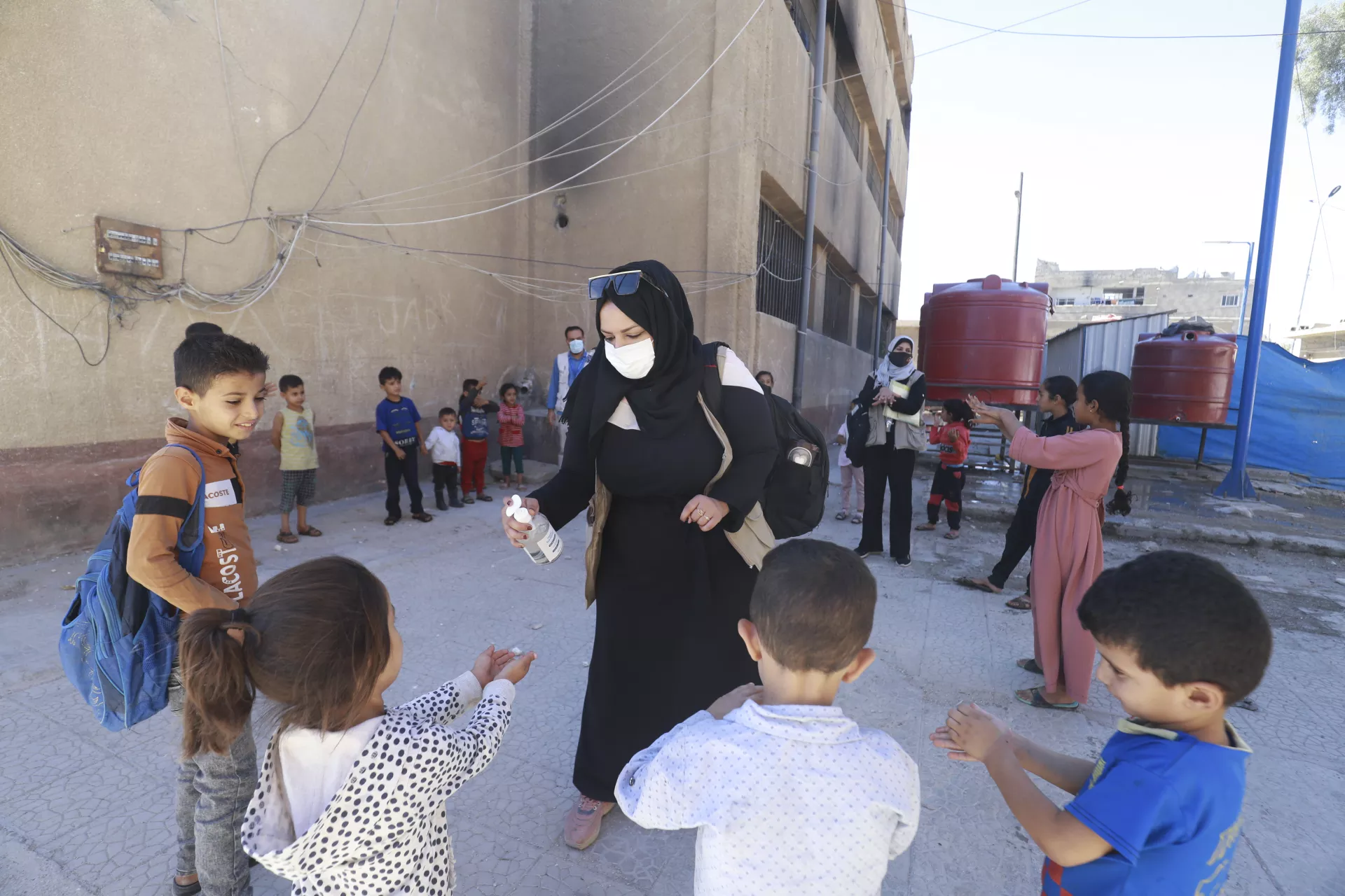 volunteer-spraying-childrens-hands-with-disinfectant