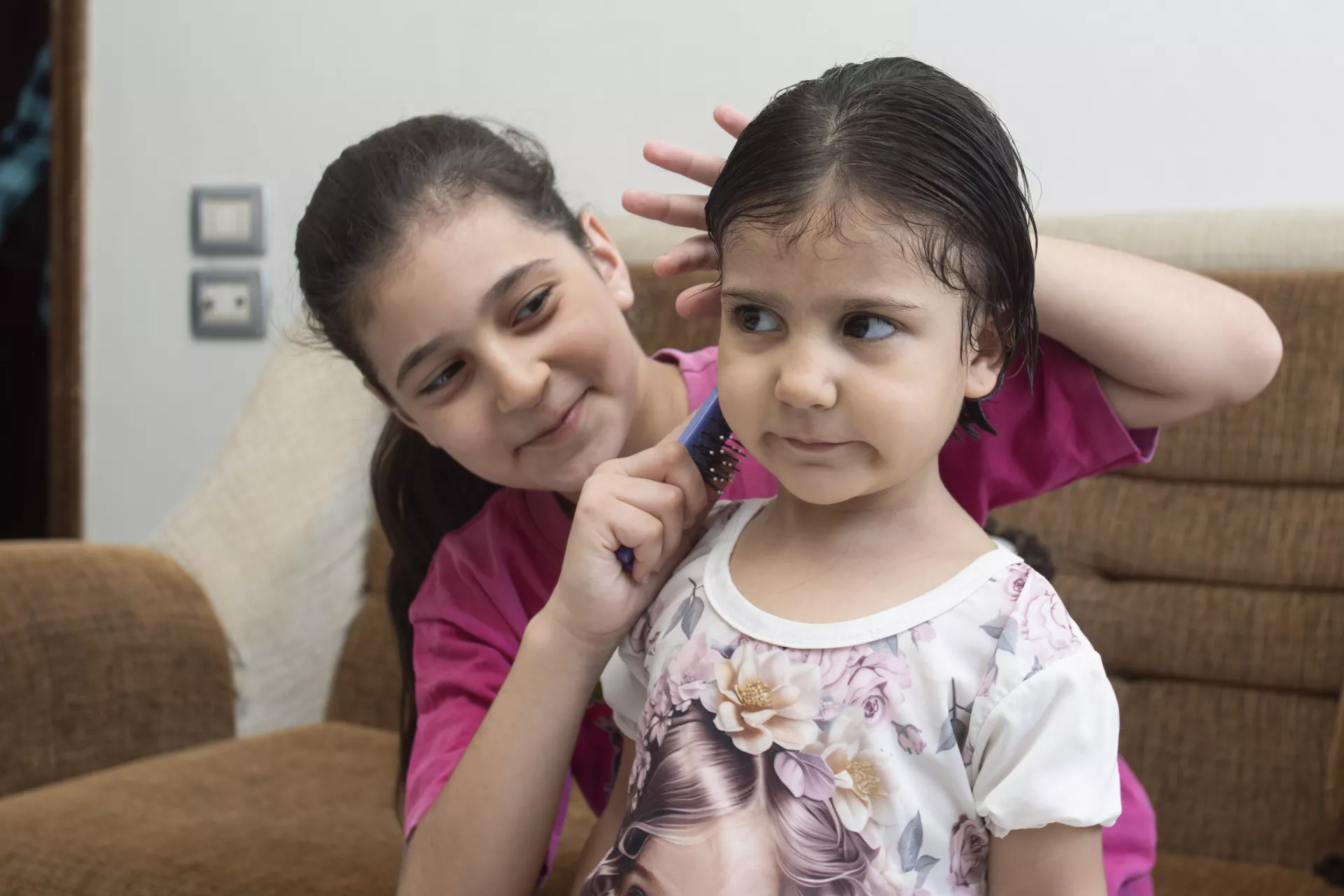 Masa, 11, combs her sister Shams&rsquo; hair at their home in Western gathering, Kisweh city, Rural Damascus.