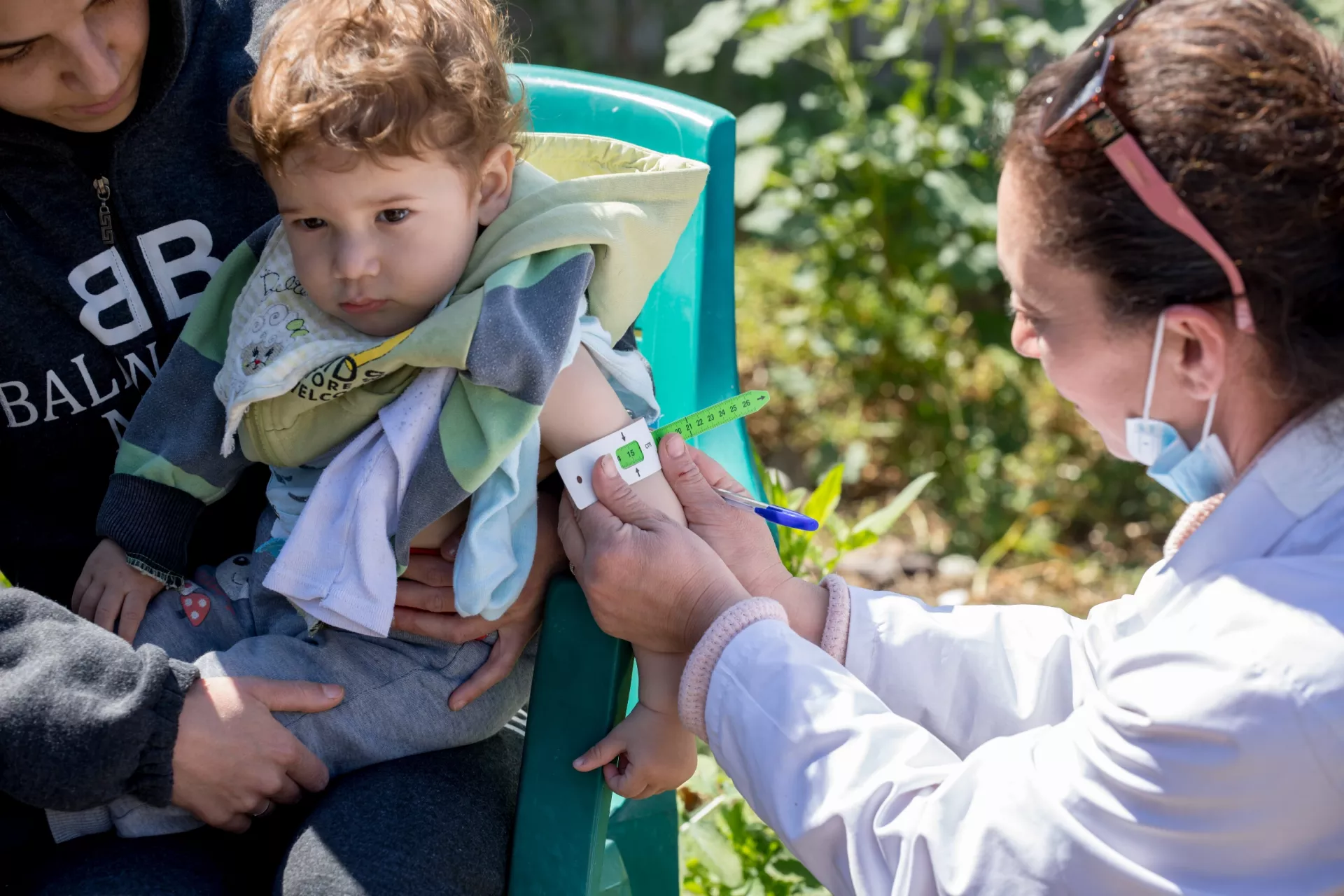 Yaman, aged 18 months, is screened for malnutrition by a health worker from a UNICEF-supported mobile health and nutrition team in rural Lattakia.