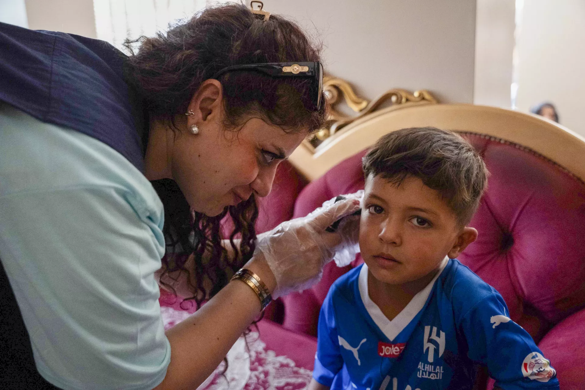 Dr. Amwaj, a paediatrician with a UNICEF-supported mobile team, examines Hayel, 5, at a shelter in Sayyeda Zeinab, Rural Damascus.