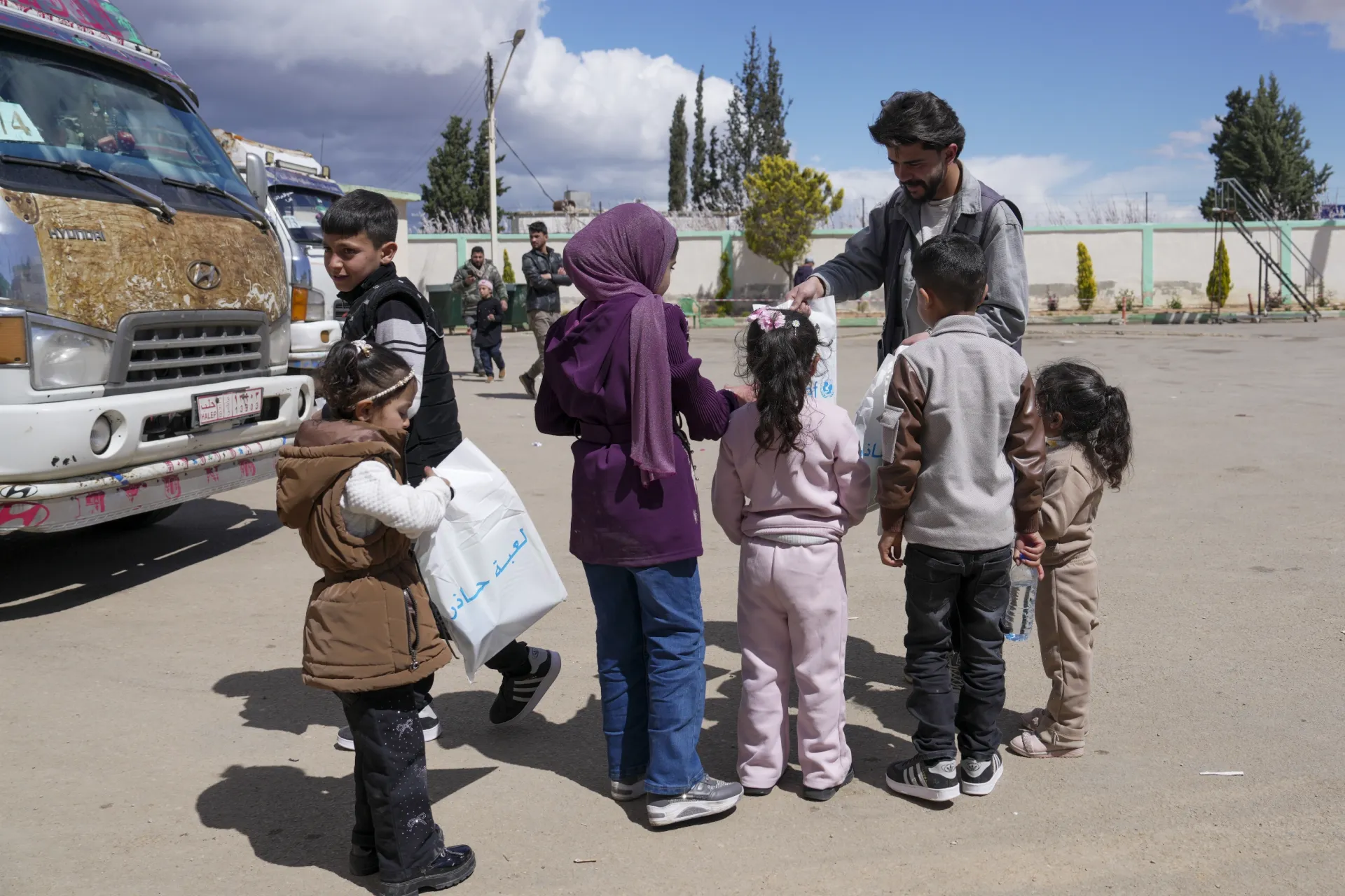 Children receive mine risk education kits from a UNICEF-supported worker.
