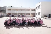 A groups of school girls sitting together in the school yard.
