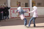 Two girls holding hands spinning around.