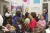 Hanan, a UNICEF-supported health worker, is surrounded by a group of young children playing with balloons