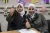 Two women sitting next to each other, smile while both give a thumbs up.