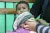 An infant boy looks up while his upper-arm circumference is measured to estanblish his nutritional status.