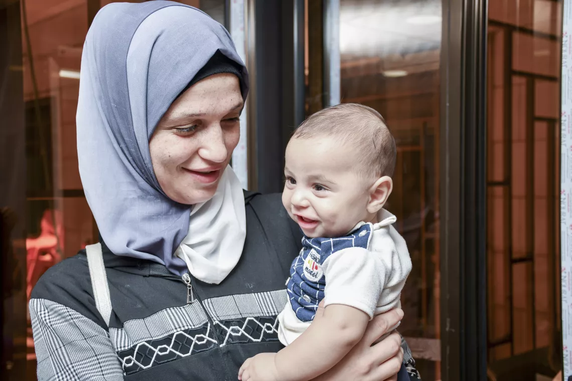 Smiling mother holding her baby boy