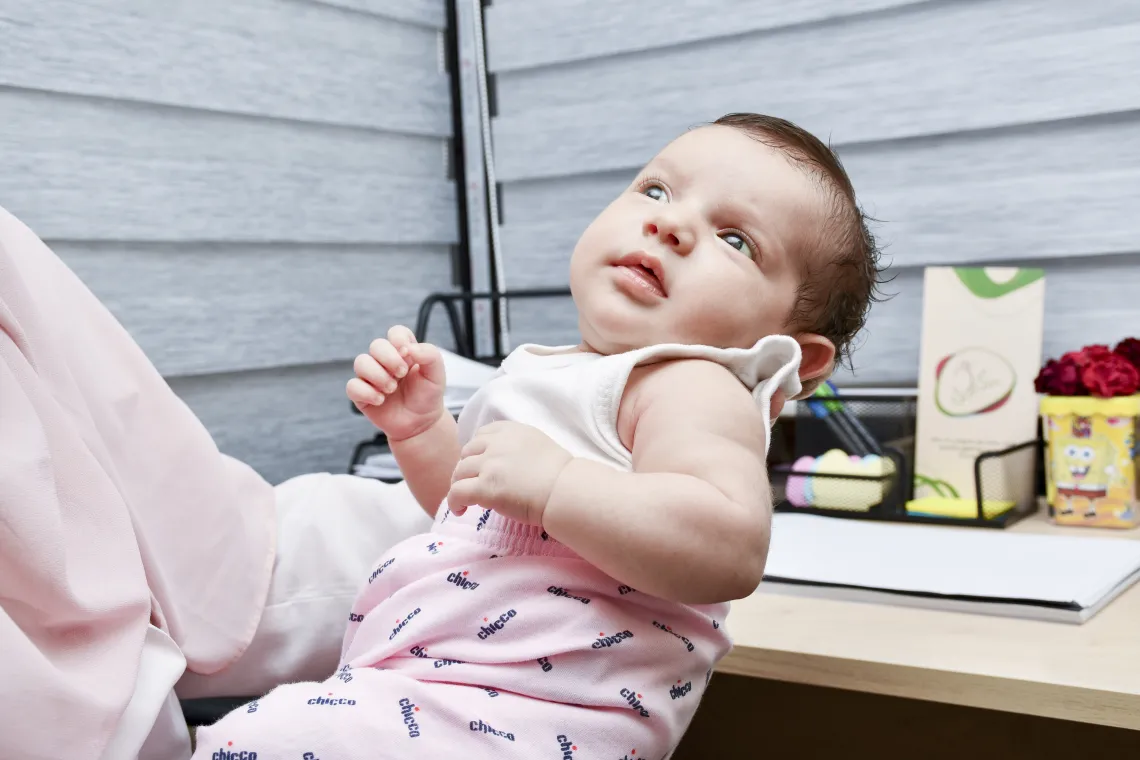 One month old baby held by her mother