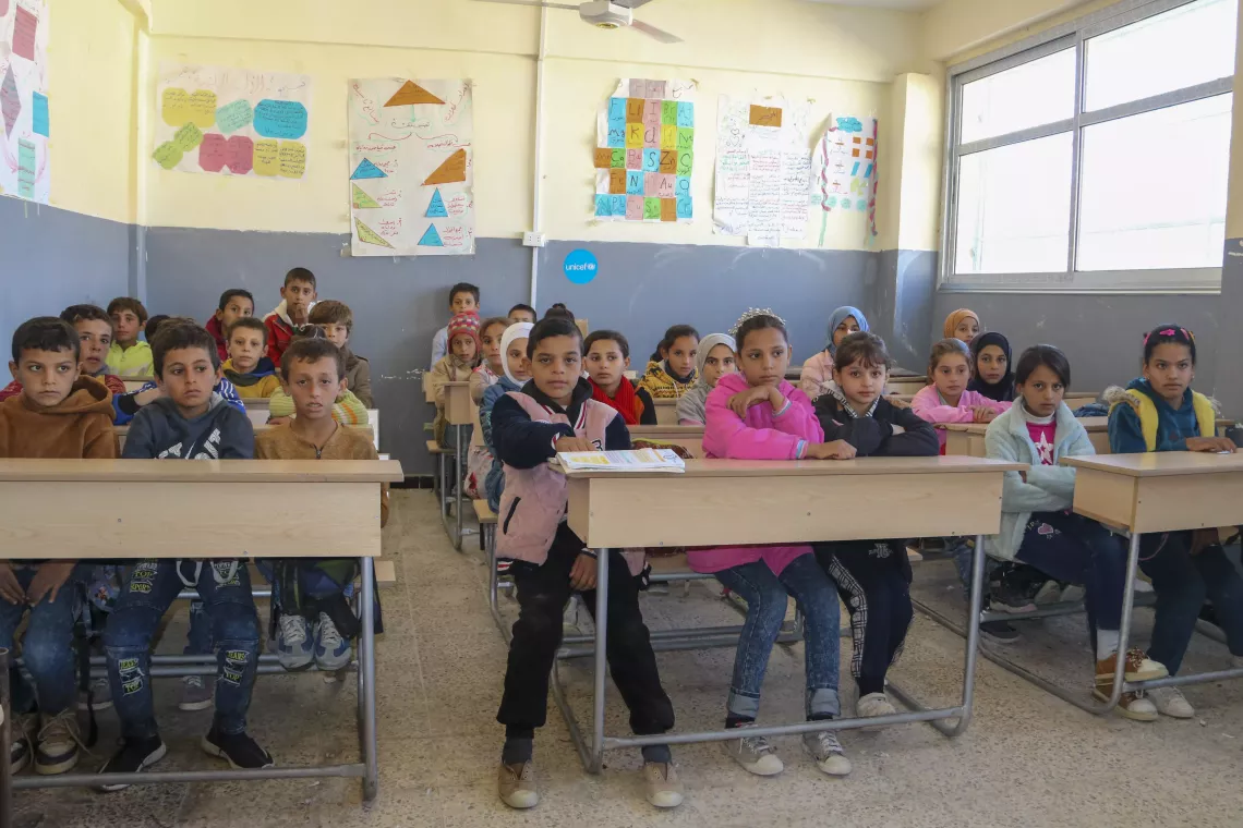 Children sit at their desks in a classroom