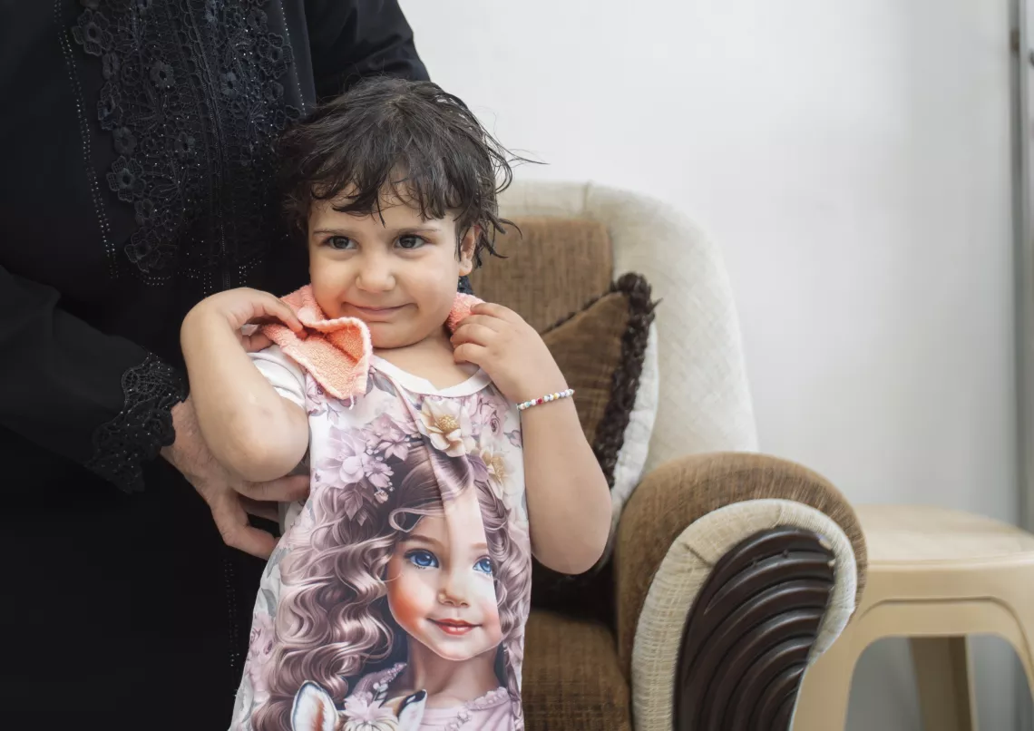 Shams, 4, has her hair dried by her grandmother at their home in Western gathering, Kisweh city, Rural Damascus.