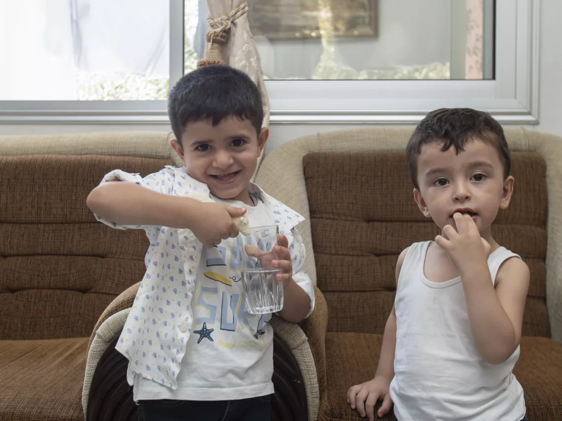 Youssef, 3, waters his toy while playing with his cousin Bisher, 2, at their grandparents' house in Western gathering, Kisweh city, Rural Damascus.