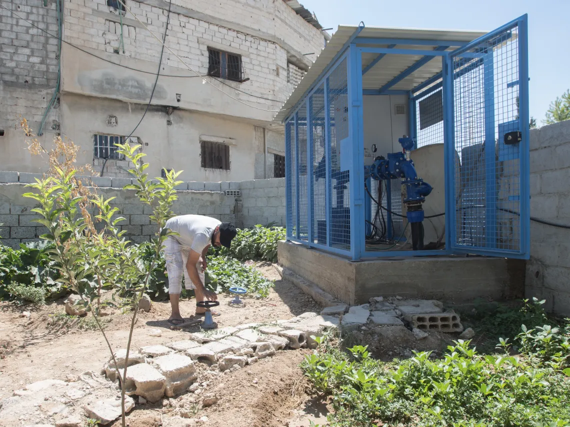 worker operates a pump at a UNICEF-rehabilitated water well, providing drinking water to Western gathering in Kisweh city, Rural Damascus.