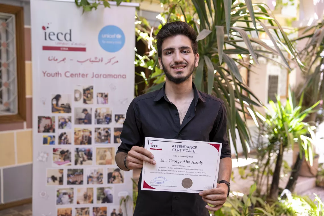 Elia, 17, proudly holds his training certificate he received at a UNICEF-supported youth-friendly space in Jaramana, Rural Damascus.