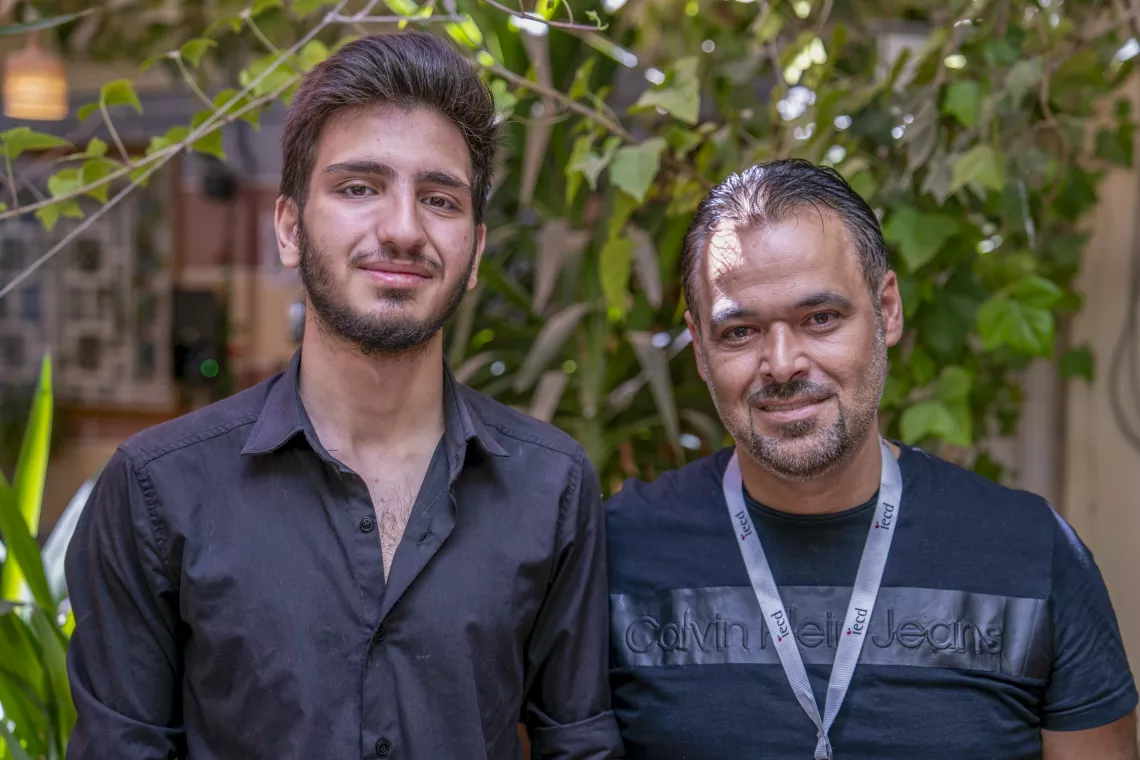 Elia, 17, stands next to his trainer at a UNICEF-supported youth-friendly space in Jaramana, Rural Damascus.