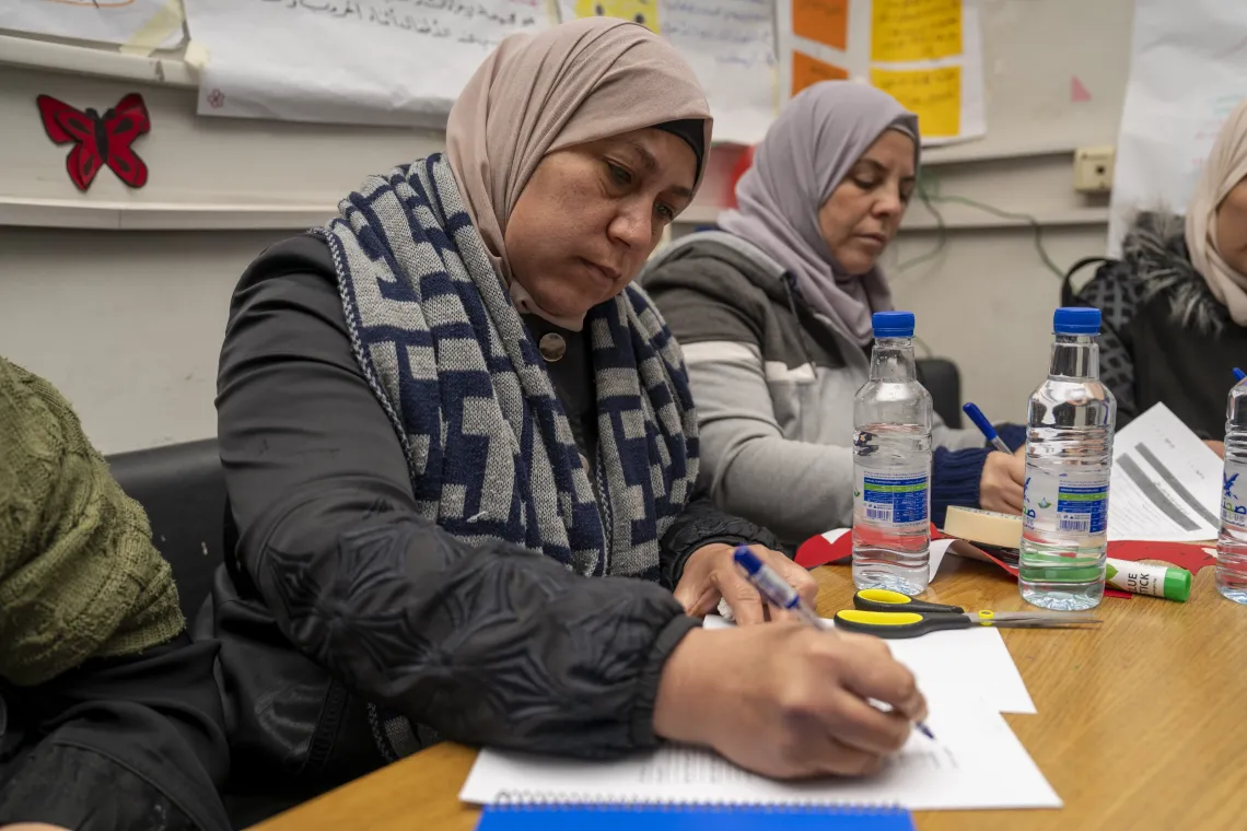 Two women taking notes.