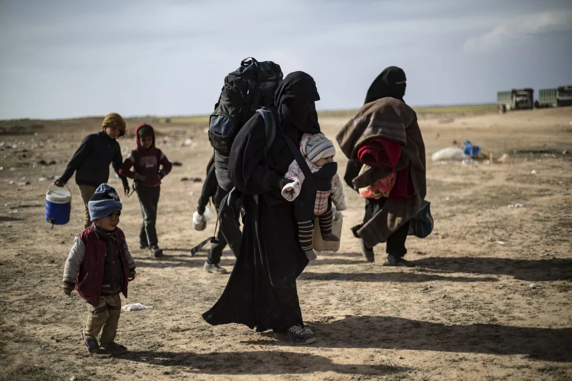 children and women walking in desert