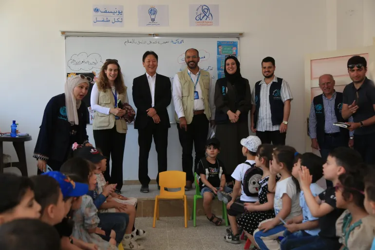 H.E. the Ambassador of the Republic of Korea, accompanied by UNICEF team, meets with a group of children during a visit to a UNICEF‑rehabilitated school in Aleppo.