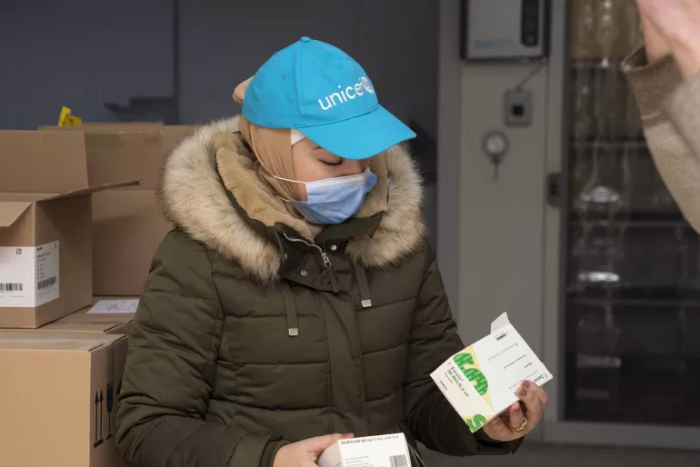 Female UNICEF staff holding medicine  