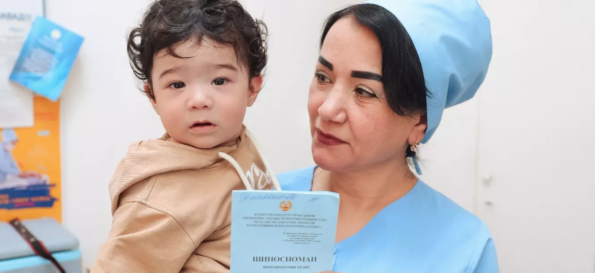 a nurse holding a smiling boy in her hands