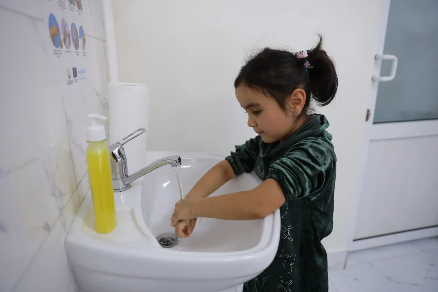A girl is washing her hands in a newly rehabilitated HCF
