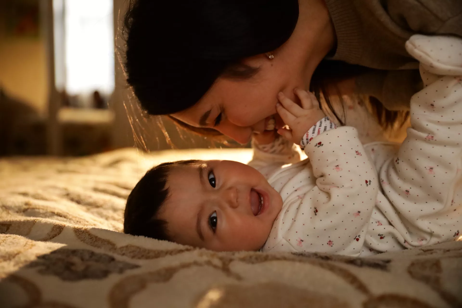 Mother cuddling with her baby girl